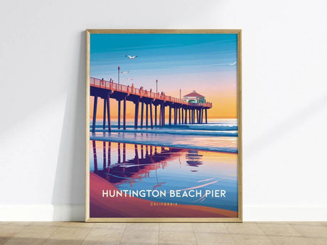 Framed poster of Huntington Beach Pier featuring a colorful sunset with reflections on the water, seagulls flying, and the pier extending into the ocean. Text reads Huntington Beach Pier, California.