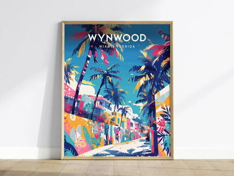 A vibrant poster of Wynwood, Miami, featuring colorful palm trees and street art under a bright blue sky. The artwork captures the lively essence of Miamis art district, displayed in a wooden frame against a plain wall.