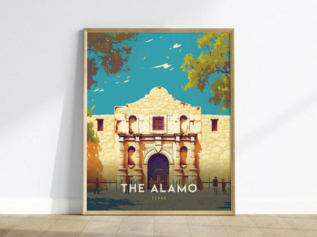 A framed poster of The Alamo features a stylized illustration of the historic mission facade against a bright blue sky, with trees and small figures in the foreground.