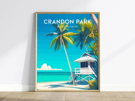 A framed poster of Crandon Park Beach, Miami, features vibrant palm trees, a white lifeguard tower, and turquoise waters under a clear blue sky. The text CRANDON PARK MIAMI FLORIDA is displayed at the top.