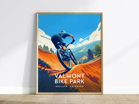 A vibrant poster shows a cyclist navigating a winding dirt trail with mountains and trees in the background, titled Valmont Bike Park, Boulder, Colorado.