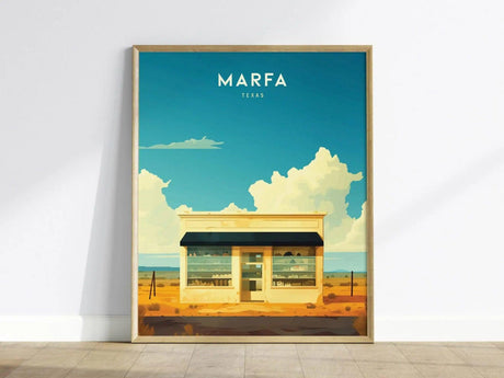 Framed Marfa Texas poster featuring a minimalist desert building under a vibrant blue sky with white clouds, capturing the essence of West Texas art installations.