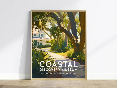 A framed poster of the Coastal Discovery Museum featuring a scenic path lined with lush greenery and trees, leading to a white Southern-style house under a clear sky.