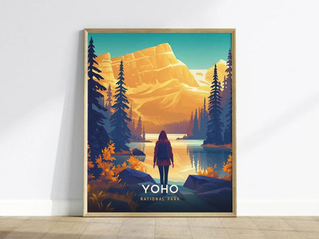 A framed poster depicts a person standing by a serene lake, surrounded by evergreen trees and mountains under a vibrant sky, labeled Yoho National Park.
