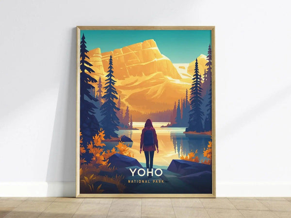 A framed poster depicts a person standing by a serene lake, surrounded by evergreen trees and mountains under a vibrant sky, labeled Yoho National Park.