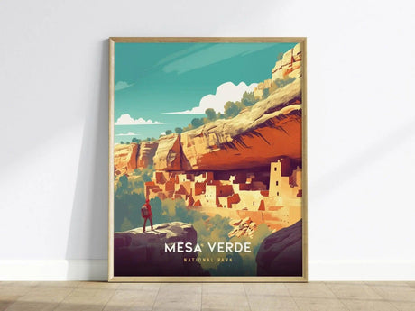 A framed poster of Mesa Verde National Park showing stylized cliff dwellings under a clear blue sky, with a person standing on a rock in the foreground.