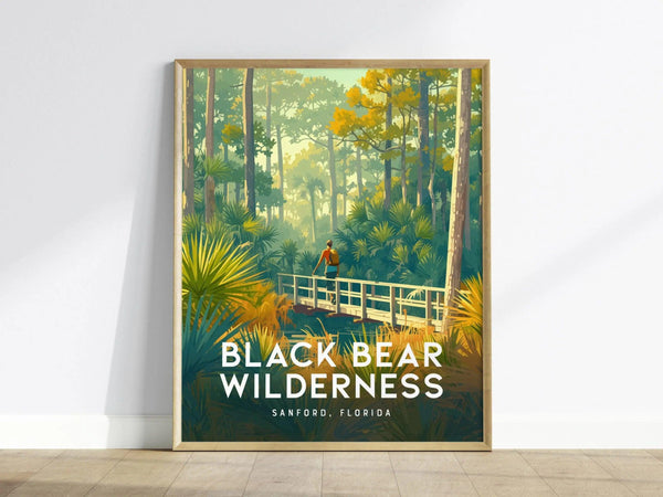 A framed poster depicts a hiker on a wooden bridge amidst dense greenery and tall trees, titled Black Bear Wilderness, Sanford, Florida.
