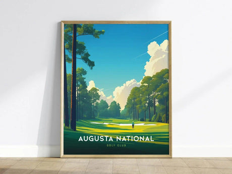 A framed poster of Augusta National Golf Club featuring lush green fairways, tall trees, and a clear blue sky with clouds, leaning against a white wall.