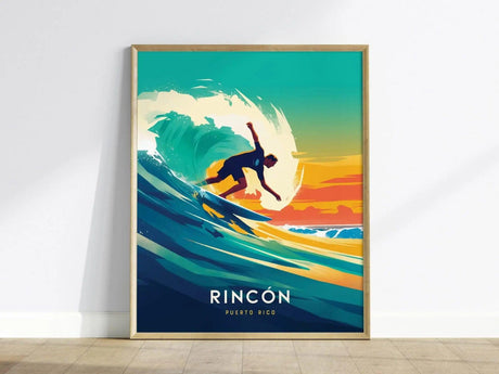 A vibrant poster depicts a surfer riding a wave against a colorful sunset, labeled Rincon Puerto Rico. The artwork features dynamic blues and oranges, framed in light wood.