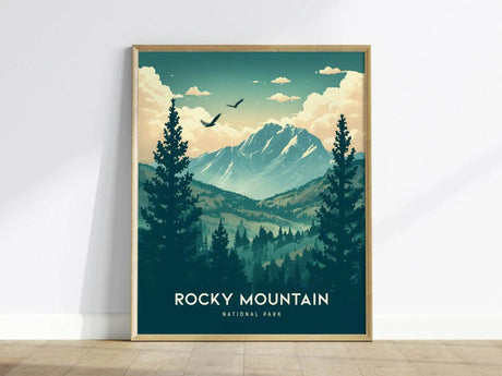 A framed poster of Rocky Mountain National Park featuring stylized mountains, pine trees, and birds under a blue sky with clouds, leaning against a white wall.
