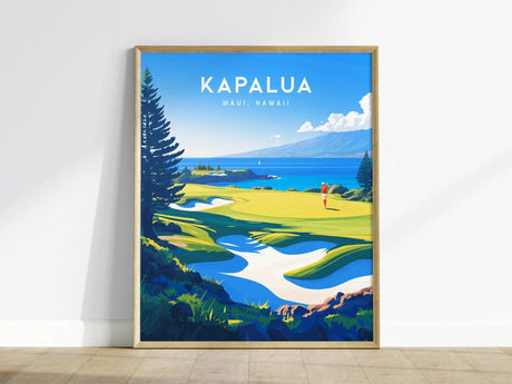 Framed poster of Kapalua Golf Course in Maui, Hawaii, featuring vibrant green fairways, ocean views, and a golfer teeing off, displayed against a light-colored wall.
