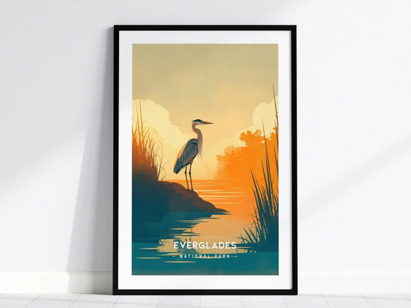 A framed minimalist poster of Everglades National Park shows a heron at the waters edge during a sunset, with soft orange.