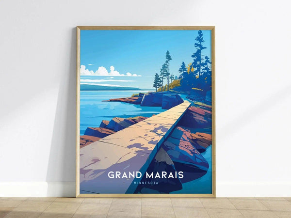 A framed poster of Artists Point in Grand Marais, Minnesota, features a vibrant landscape with a rocky shoreline, pine trees, and a clear blue sky.