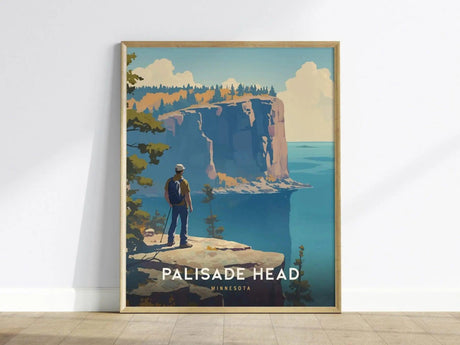 A framed poster depicts a hiker overlooking the dramatic cliffs of Palisade Head against a backdrop of Lake Superior and forested hills. The artwork is vibrant and scenic.