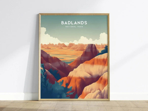 Framed art print featuring a stylized depiction of Badlands National Park with colorful rock formations and a vibrant sky, resting against a white wall on a wooden floor.