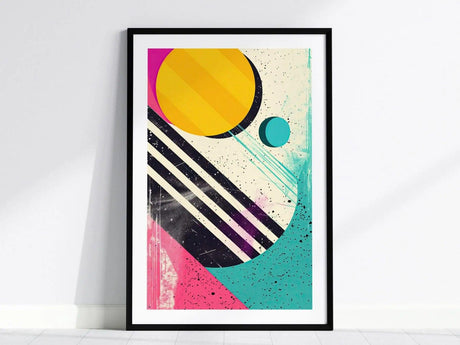 A framed poster featuring bold geometric shapes, including a large yellow circle, black diagonal stripes, and vibrant splashes of pink and teal, creating a retro 1980s aesthetic.