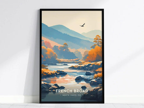 Framed artwork depicting the French Broad River in North Carolina, featuring a serene landscape with mountains, autumn trees, and a bird soaring in the sky.