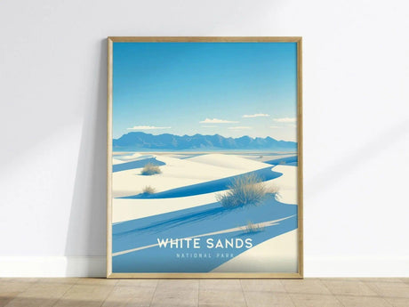 A framed poster of White Sands National Park features white gypsum sand dunes under a clear blue sky, with distant mountains and sparse vegetation.