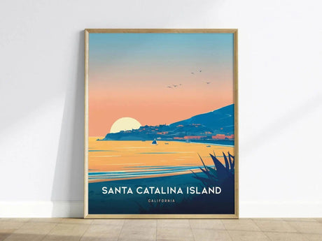 Framed poster of Santa Catalina Island depicting a vibrant sunset over the ocean with a sailboat and birds in the sky. The artwork features bold colors and a serene landscape.