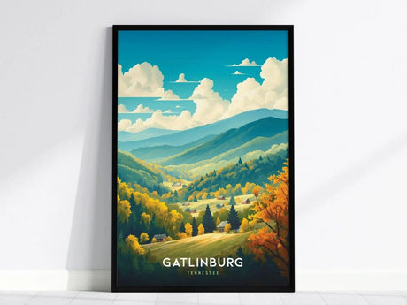 Framed poster depicting a vibrant illustration of Gatlinburg, Tennessee, featuring lush green mountains, colorful autumn trees, and fluffy clouds against a bright blue sky.