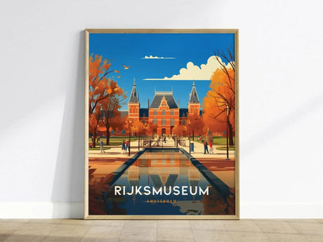 A framed poster depicts the Rijksmuseum in Amsterdam, surrounded by autumn trees, with a clear blue sky and its reflection in a canal. The word Rijksmuseum is prominently displayed.