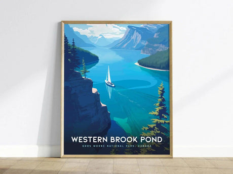 A framed poster of Western Brook Pond depicts a sailboat on vibrant blue water surrounded by towering cliffs and lush greenery, showcasing the stunning landscape of Gros Morne National Park.