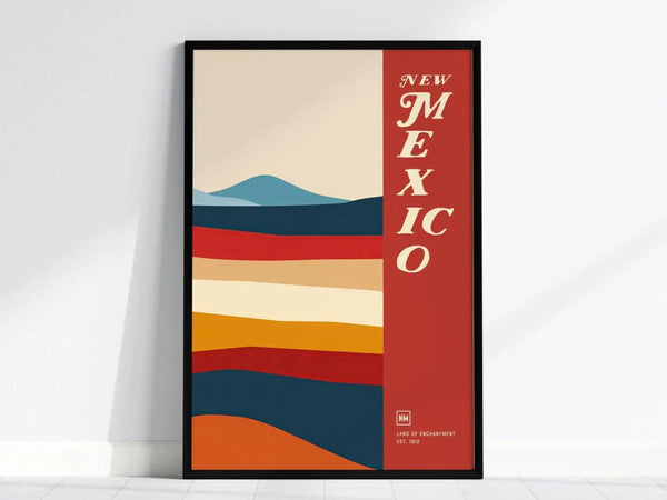 Framed poster featuring abstract, colorful horizontal stripes resembling a desert landscape, with New Mexico in bold text on a red vertical band.