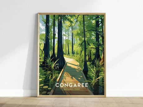 Framed poster depicting a wooden boardwalk winding through a lush green forest with tall trees and sunlight filtering through. The text Congaree National Park is visible at the bottom.
