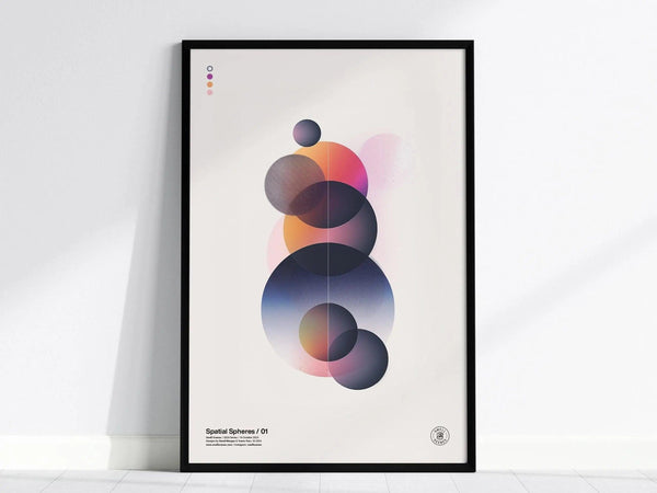A modern abstract art poster featuring overlapping spheres with gradient transitions in shades of blue, pink, and orange, displayed in a black frame against a white wall.