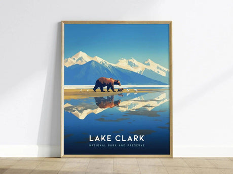 Framed poster of Lake Clark National Park, featuring a bear with cubs on a reflective lake, against a backdrop of snow-capped mountains and a clear blue sky.