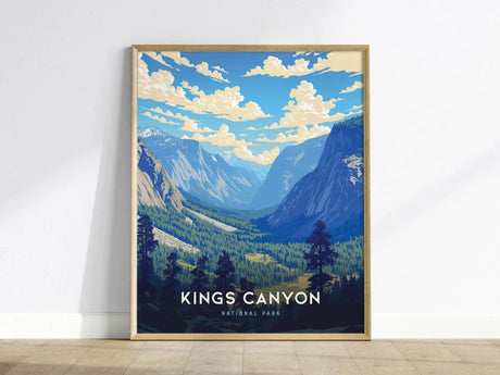 Framed poster of Kings Canyon National Park featuring stylized blue and green mountains under a sky with fluffy clouds, resting on a wooden floor against a white wall.
