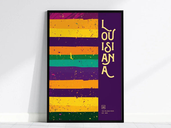 A framed poster features colorful horizontal stripes in purple, orange, and green with the word LOUISIANA in yellow text on a purple background. The design is vibrant.