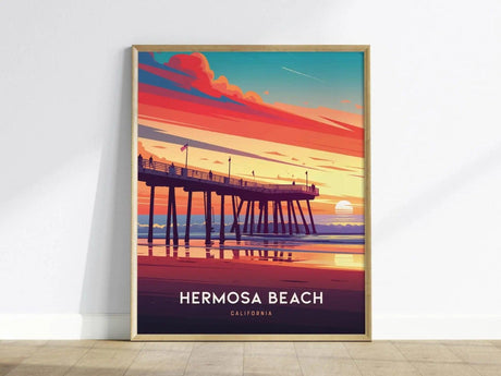 Framed poster of Hermosa Beach Pier at sunset, featuring vibrant hues of orange, pink, and blue skies over the ocean. Text at the bottom reads Hermosa Beach, California.