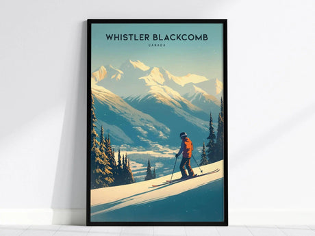 A framed poster of Whistler Blackcomb shows a skier on a snowy slope with majestic mountains and evergreen trees in the background, under a clear blue sky.