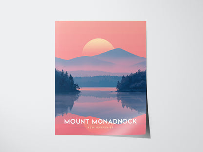 A poster of Mount Monadnock features a serene lake with pine trees, a mountain silhouette, and a setting sun against a pink sky. The text reads Mount Monadnock, New Hampshire.