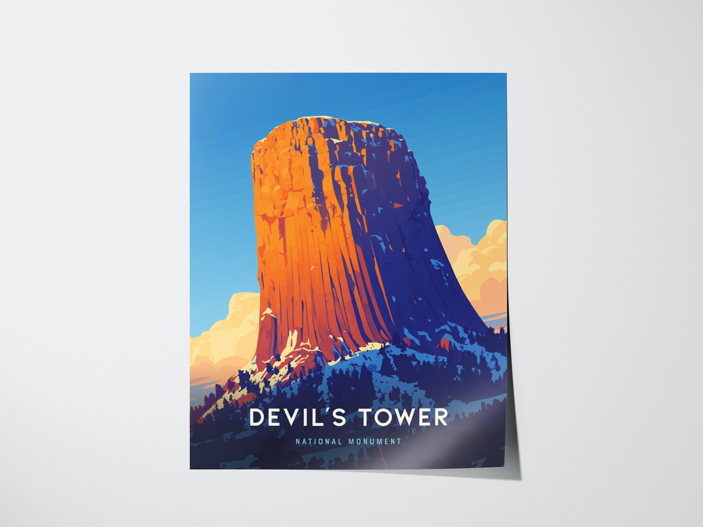 A vibrant poster depicts Devils Tower against a clear blue sky, with warm orange hues highlighting the geological formation. Text reads Devils Tower National Monument at the bottom.