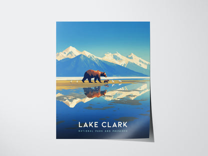 Illustrated poster of Lake Clark National Park features a bear with cubs on a beach, snow-capped mountains, and a reflective lake. Text reads Lake Clark National Park and Preserve.
