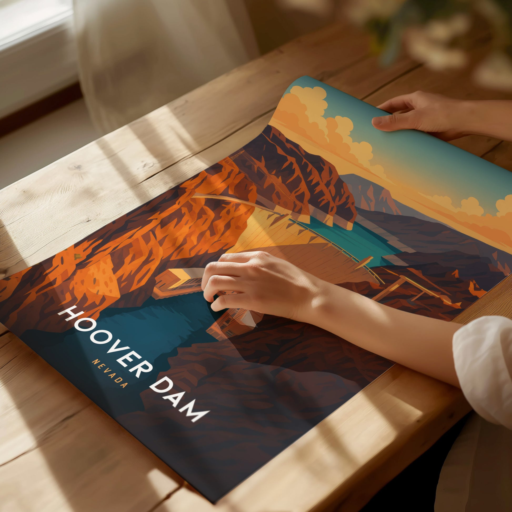 A person is holding a colorful poster of the Hoover Dam on a wooden table, featuring bright orange canyon walls and blue water under a sky with fluffy clouds. The words Hoover Dam Nevada are displayed prominently.