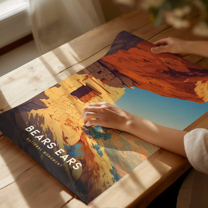 A person examines a vibrant poster of Bears Ears National Monument, depicting red sandstone cliffs and ancient ruins, on a wooden table with soft natural light streaming.