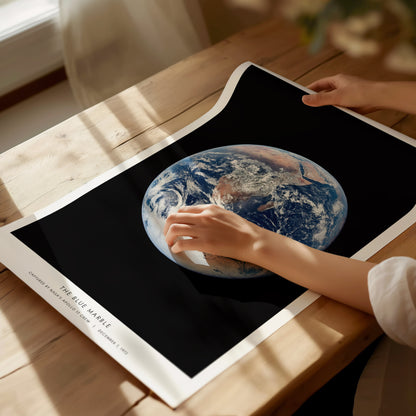Unframed Blue Marble Earth-from-space poster printed on matte archival paper laid flat on a tabletop