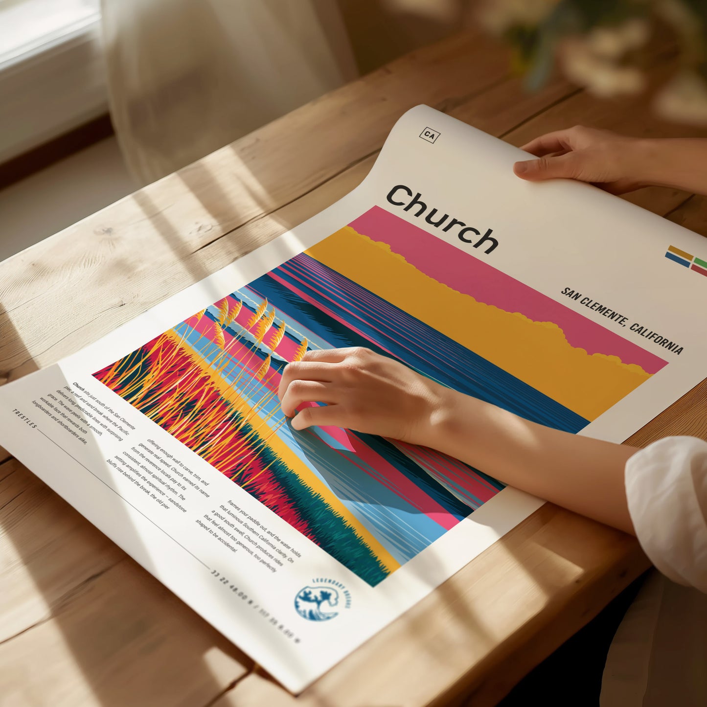 A person is holding a colorful poster titled Church, featuring vibrant abstract lines and patterns representing a surf break, with text indicating its location in San Clemente, California.