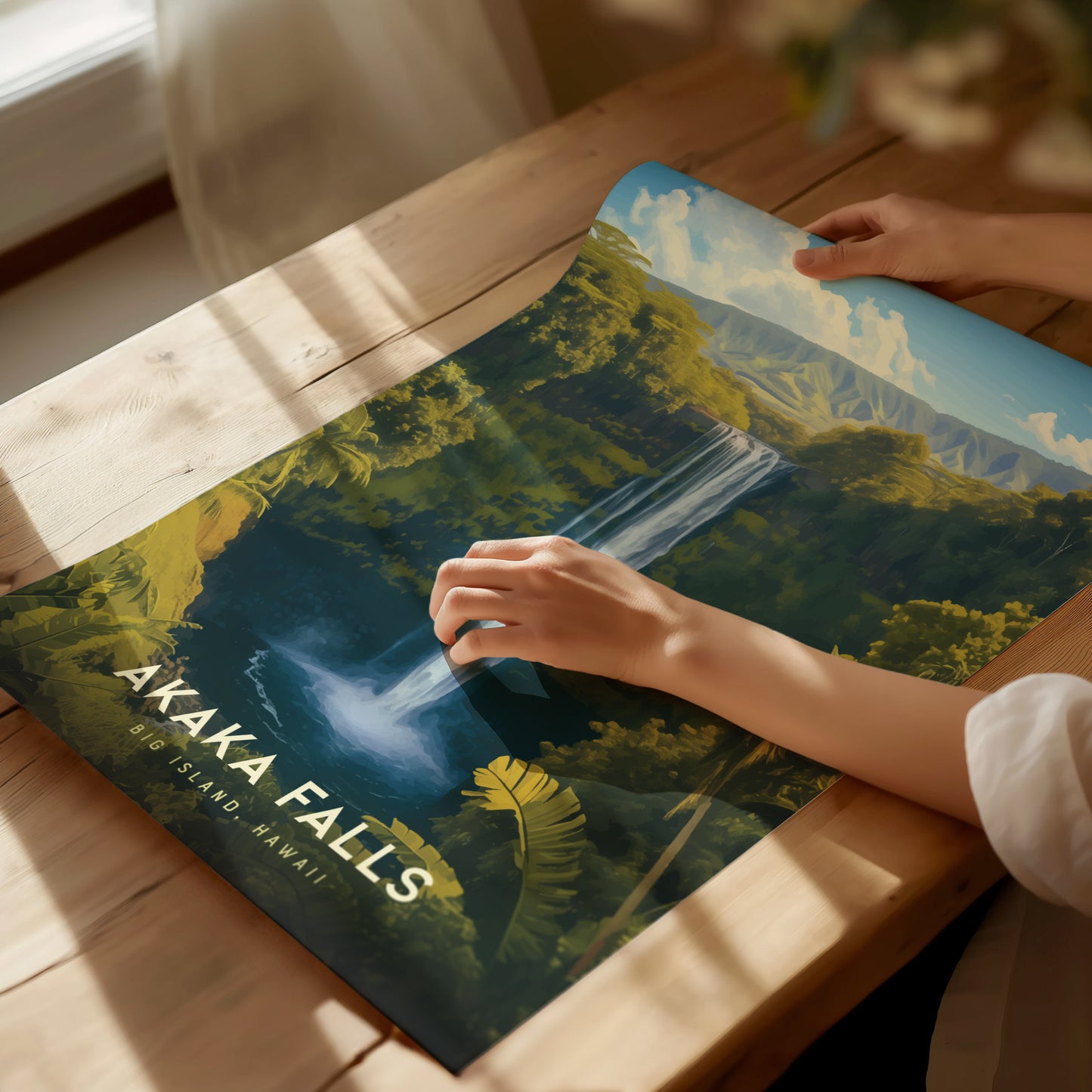 A person examines a vibrant poster of Akaka Falls, depicting a cascading waterfall surrounded by lush greenery, on a wooden table. The text reads Akaka Falls, Big Island, Hawaii.