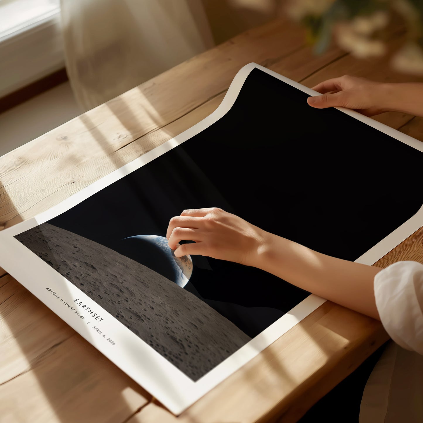 Framed NASA "Earthset" poster showcasing Earth rising over the Moon's horizon, featuring deep black space and textured gray lunar surface.
