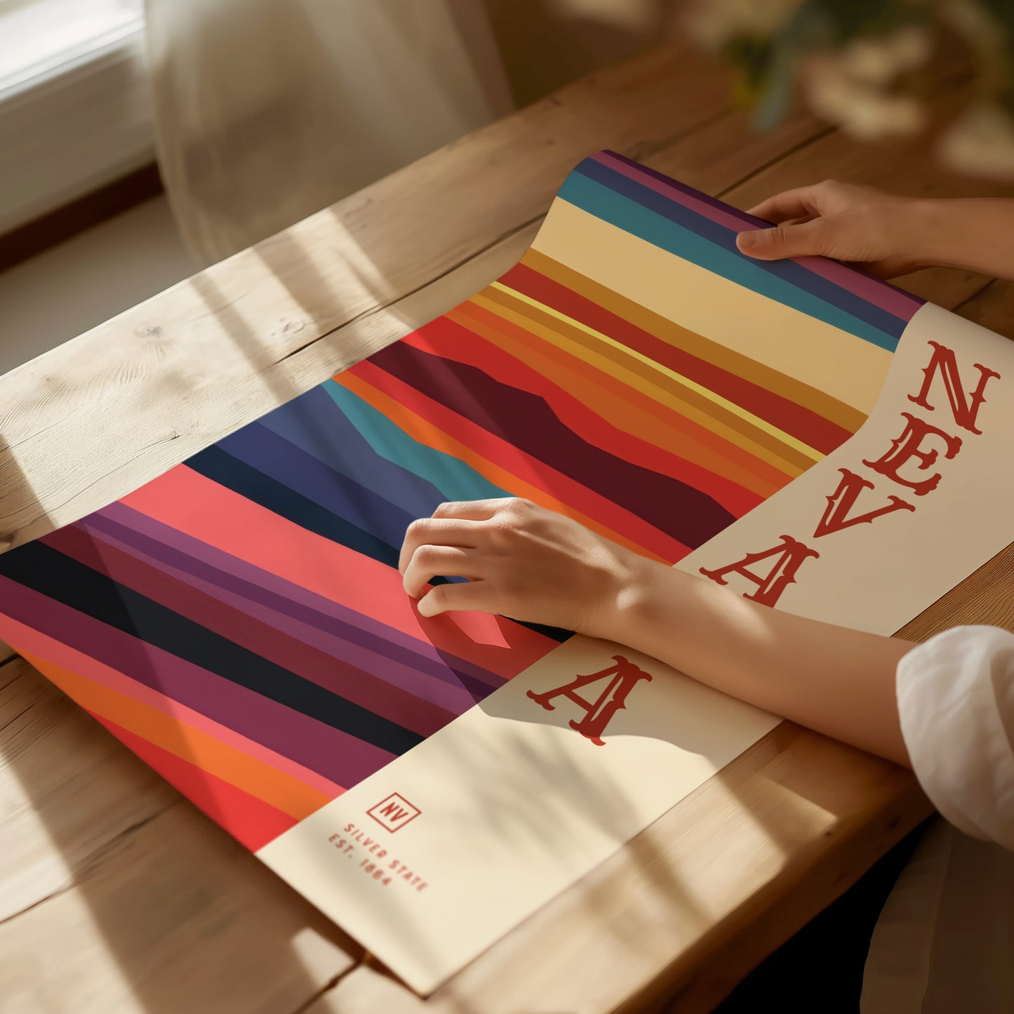 A person rolls out a colorful Nevada State poster featuring bold, horizontal stripes and the word NEVADA in red letters.