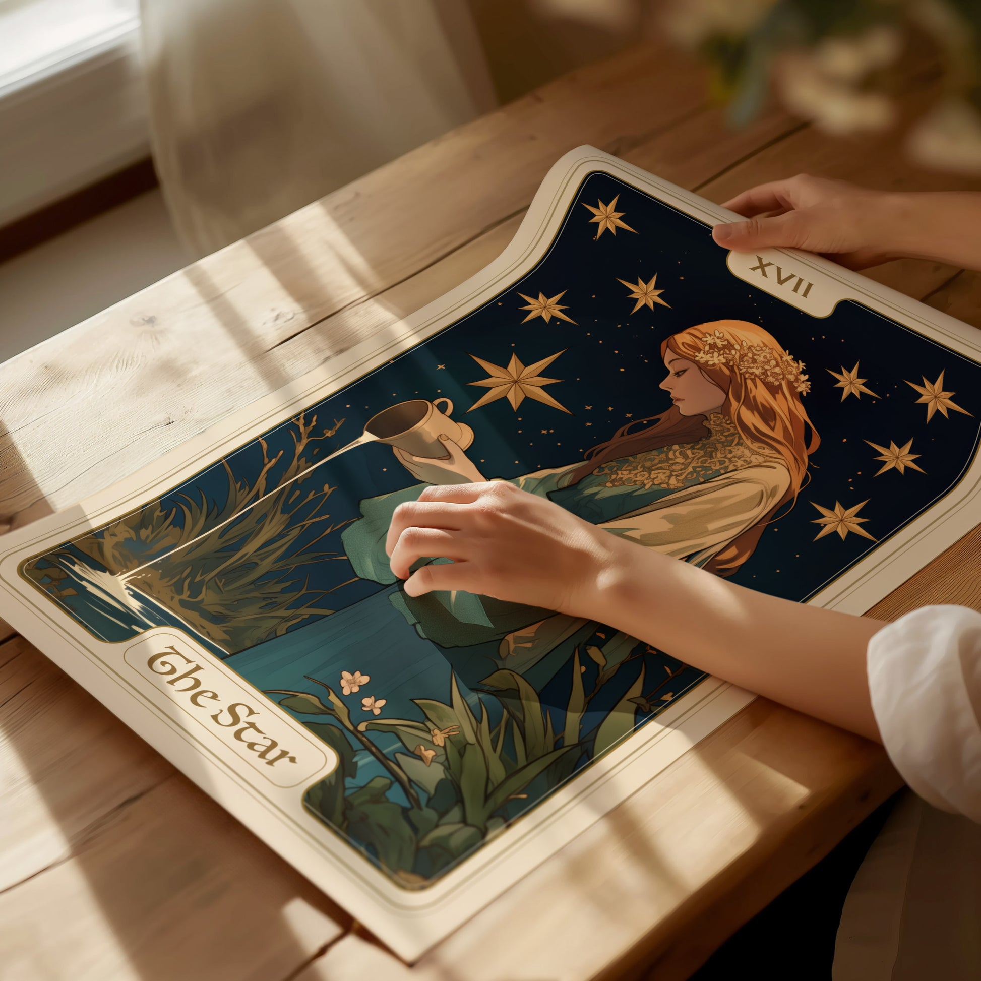 A person is gently touching a tarot poster featuring a serene maiden with long hair, surrounded by stars, labeled XVII The Star, lying on a wooden table.