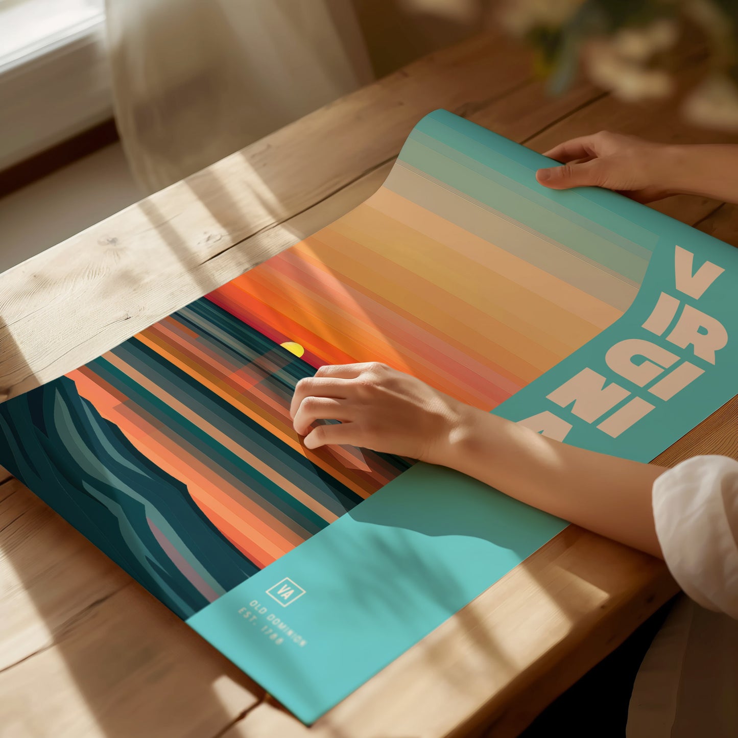 A person holds a colorful poster featuring abstract landscape patterns with warm tones, titled VIRGINIA in bold letters.