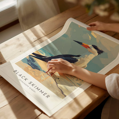 A person gently touches a vibrant poster featuring a Black Skimmer, showcasing the birds striking blue and white plumage against a sandy background. The artwork captures the coastal beauty and elegance of this shorebird in a serene setting.