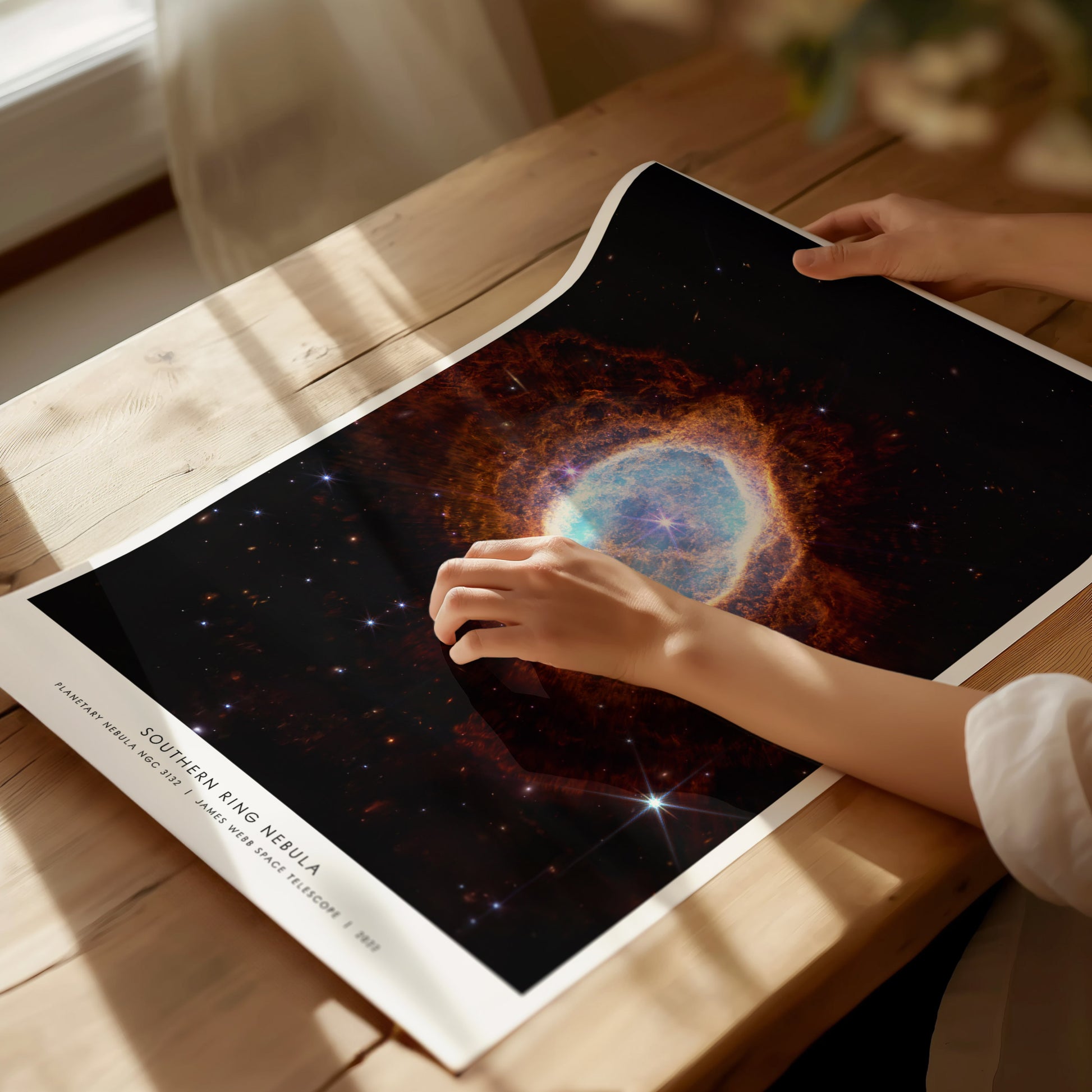Unframed Southern Ring Nebula JWST poster printed on matte archival paper laid flat on a tabletop