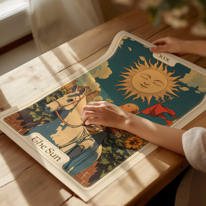 A person gently holds a vibrant tarot card poster featuring a joyous child on a white horse beneath a radiant sun, surrounded by sunflowers, on a wooden table.