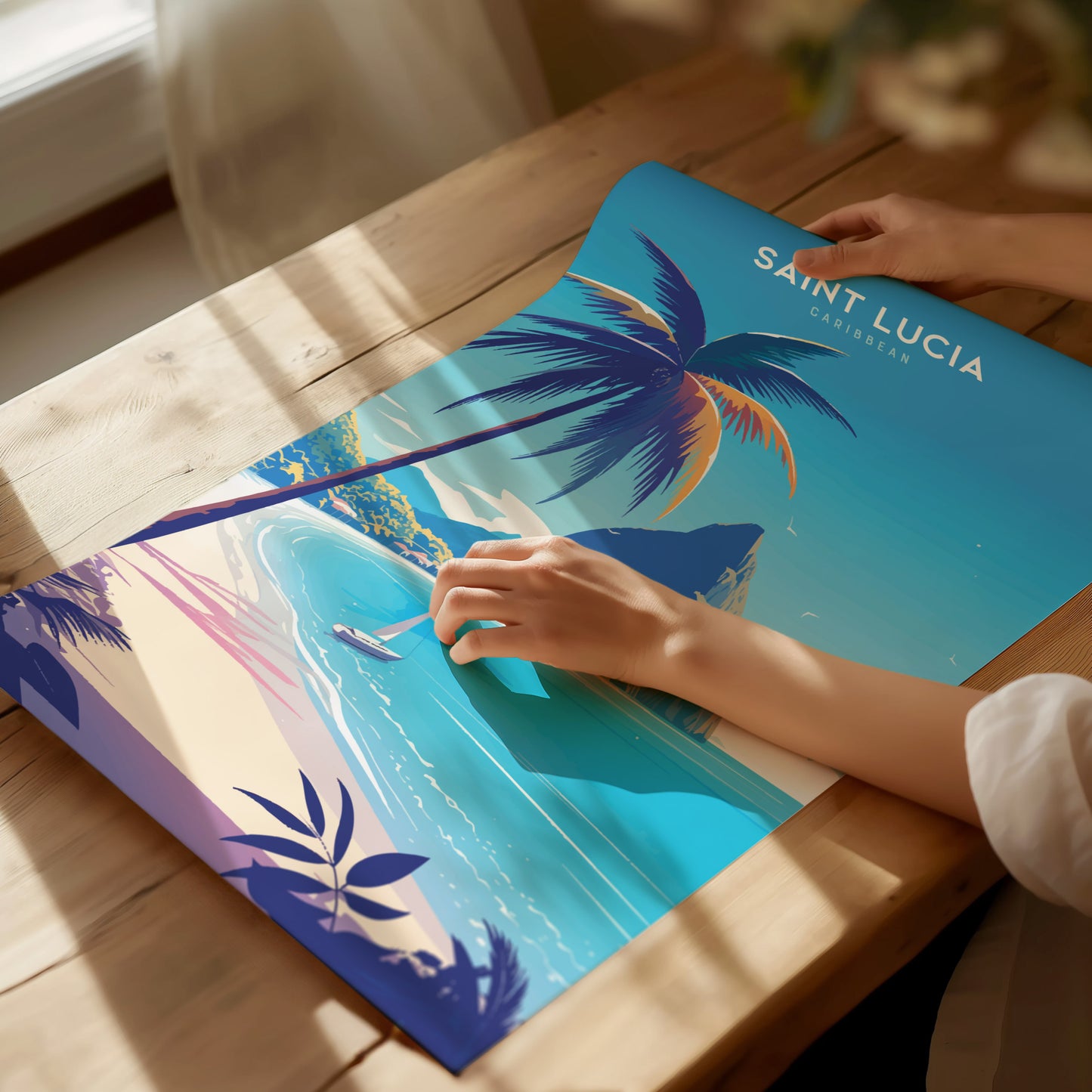 A person holds a vibrant poster of Saint Lucia featuring a tropical beach scene with palm trees, turquoise waters, and mountains. Sunlight casts soft shadows on the wooden table.
